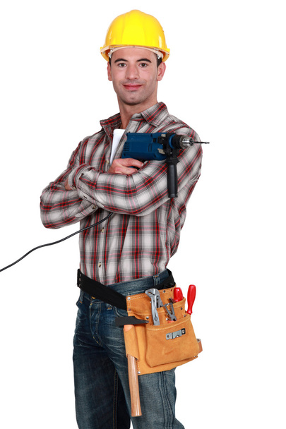 Proud tradesman posing with his electric screwdriver - 写真・画像