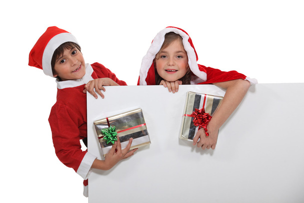 Children dressed in Christmas costume with gifts - 写真・画像