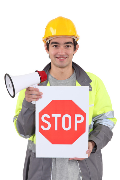 Tradesman holding a stop sign and a megaphone - Foto, Bild