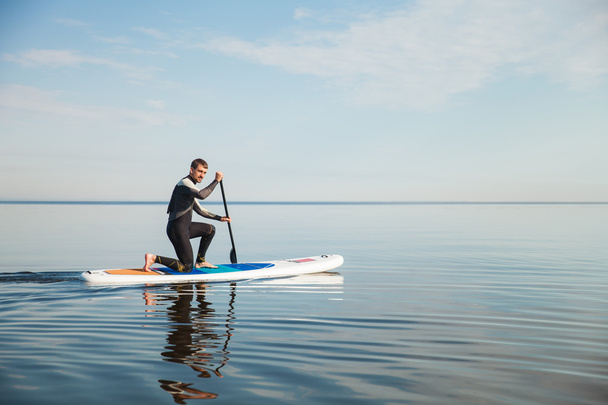 Young man paddling on sup board - Photo, Image