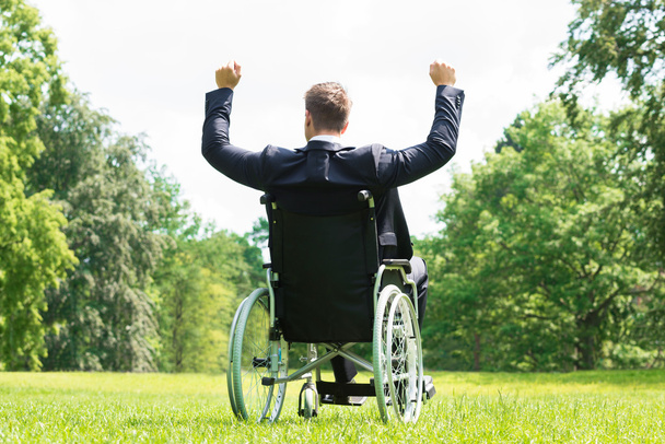 Young Disabled Man On Wheelchair With Arm Raised - Φωτογραφία, εικόνα