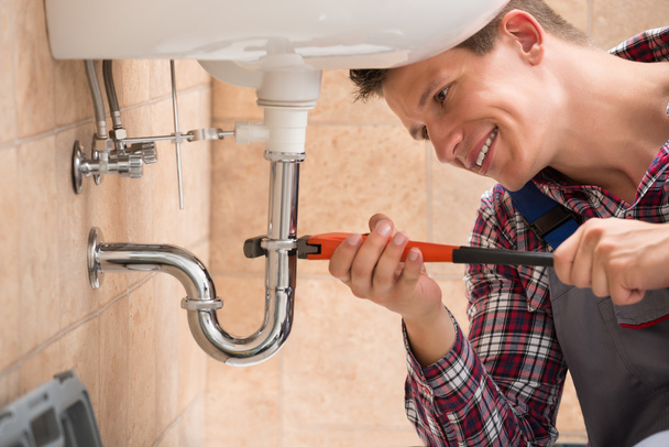 Plumber Fixing Sink Pipe With Adjustable Wrench - Foto, immagini