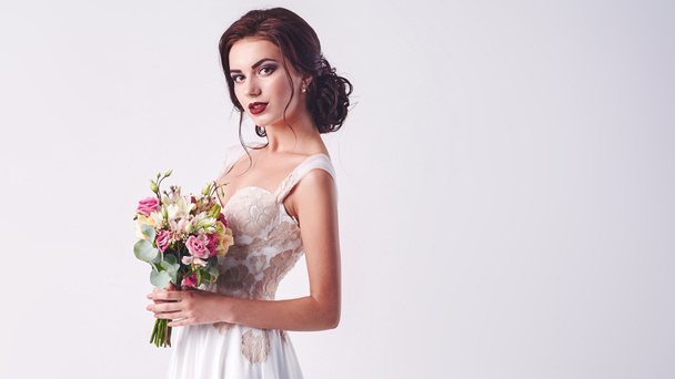Young attractive bride with the bouquet of white roses - Photo, image