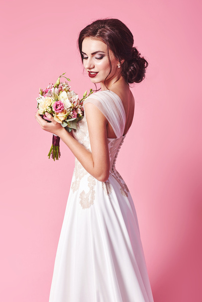Bride.Young fashion model with perfect skin and make up, beige background, curly hair, flowers in hair - Zdjęcie, obraz