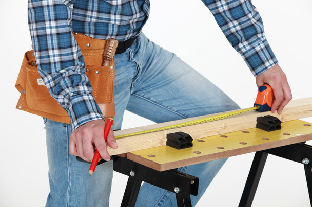 Carpenter measuring wood - Foto, imagen