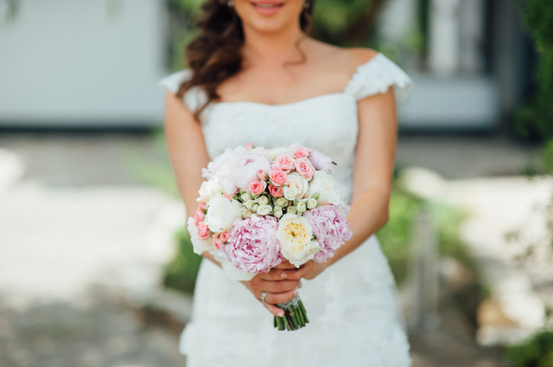 Bride holding wedding bouquet on ceremony - Фото, изображение