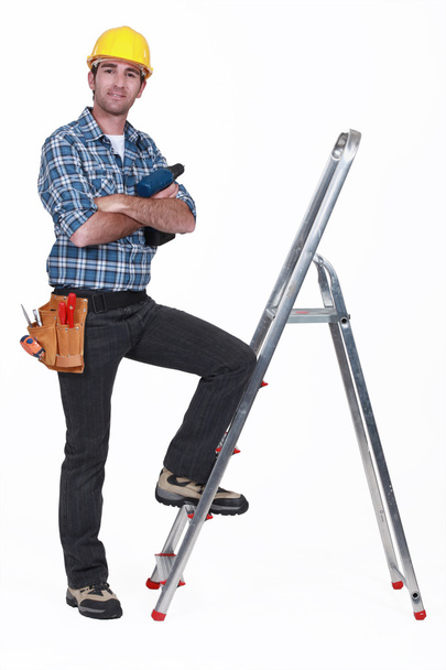 Portrait of a tradesman with his foot propped on a stepladder - Foto, Bild
