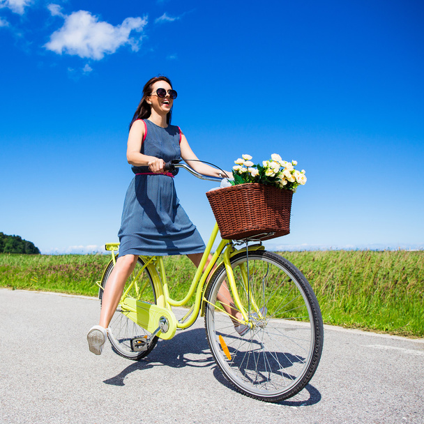 happy funny young woman riding on bicycle with raised legs - Фото, зображення