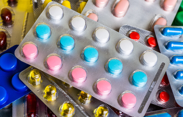 Medicine green and yellow pills or capsules. Antibiotic closeup. - 写真・画像
