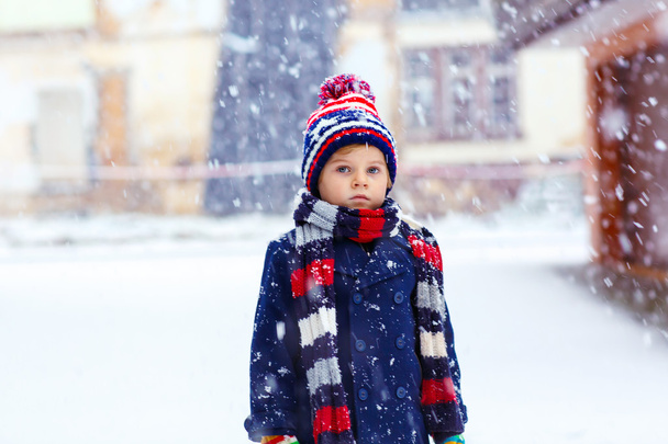 Szczęśliwy chłopiec bawiący się śniegiem w zimie - Zdjęcie, obraz