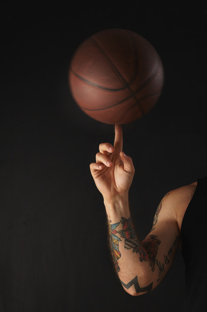 Leather basketball ball spins over on finger - Foto, afbeelding