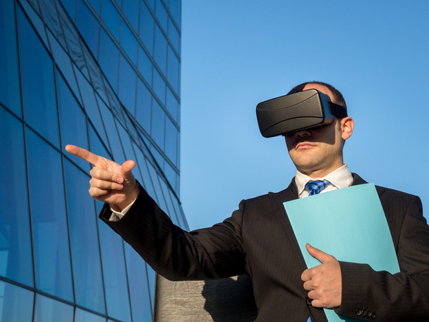 Uomo d'affari che utilizza occhiali di realtà virtuale per un incontro nel cyberspazio
 - Foto, immagini