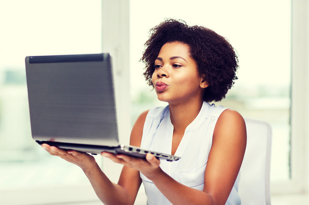 african woman sending kiss to laptop computer - Photo, Image