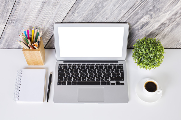 Tvůrčí návrháře desktop s prázdné bílé laptop, Poznámkový blok, pera, tužky, šálek kávy a rostlin na dřevěné pozadí. Vysmívat se - Fotografie, Obrázek