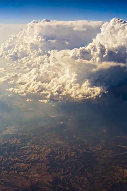 βουνό που φαίνεται μέσα από τα σύννεφα από το αεροπλάνο - Φωτογραφία, εικόνα