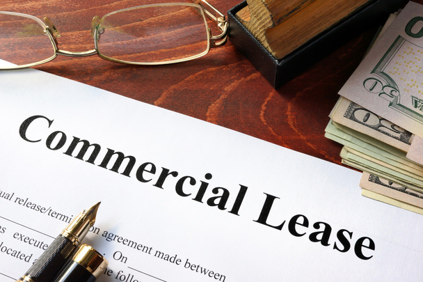 Commercial Lease agreement with money on a table. - 写真・画像
