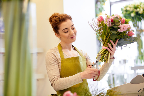 smiling florist woman making bunch at flower shop - Valokuva, kuva