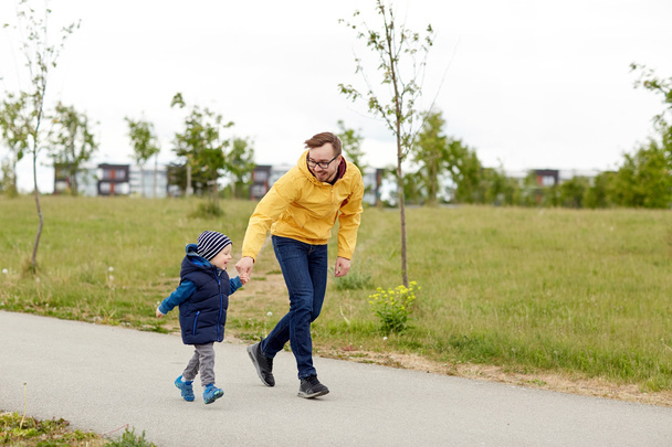 happy father and little son walking outdoors - Foto, afbeelding
