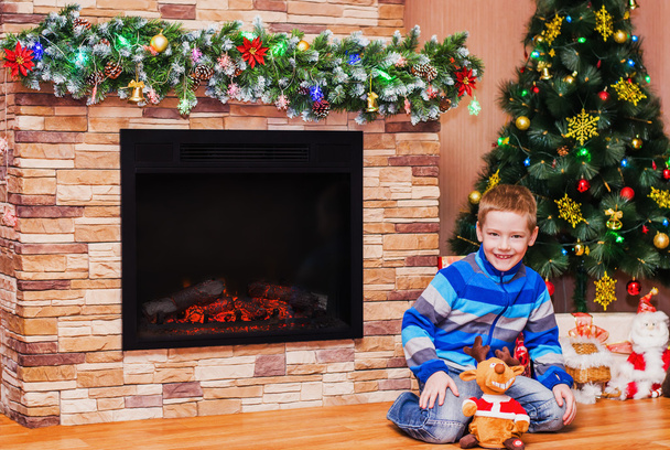 Boy sitting on floor near Christmas tree - Valokuva, kuva