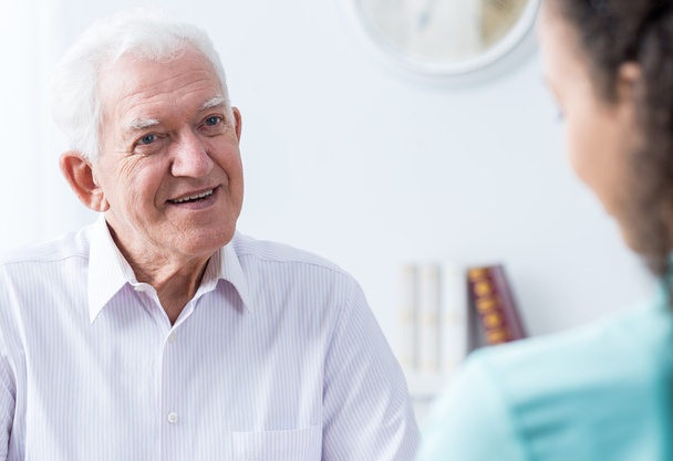 Senior man talking to caregiver - Foto, afbeelding