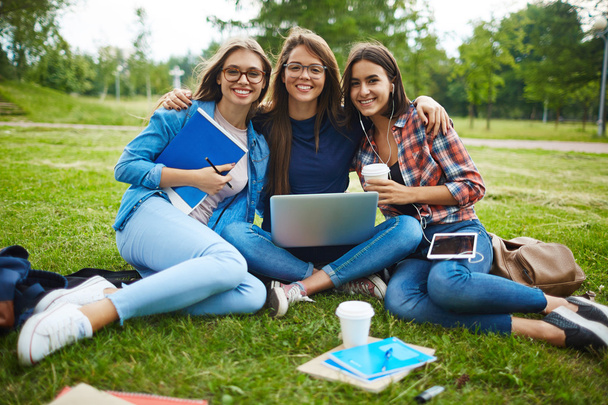 Three friends sitting on lawn at leisure  - Photo, image