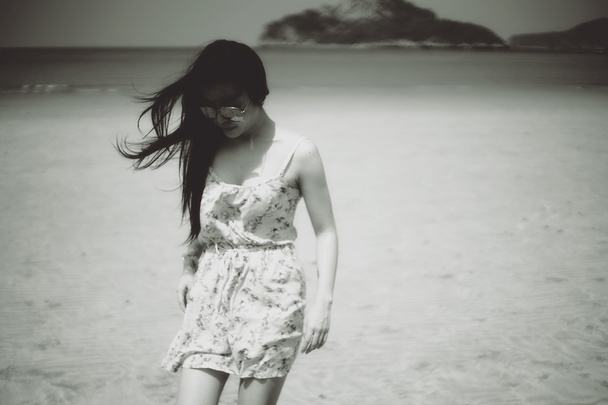 Ázsia nő a strandon és a szél fújja a haját, fekete-fehér Vintage képstílus, szelektív fókusz, lágy fókusz hatása, szűrt kép - Fotó, kép