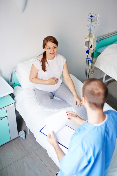 zwangere vrouw praten met arts - Foto, afbeelding