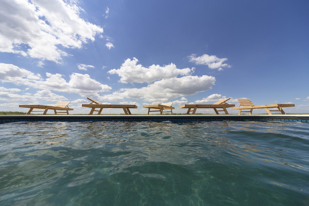 Increíbles vistas sobre la zona de la piscina con tumbonas de madera
. - Foto, Imagen