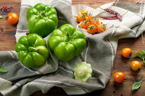 Fresh juicy green peppers, squash and yellow tomatoes on a brown wooden background. farm food concept. Vegetable about (background) - Valokuva, kuva