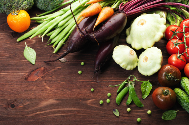 菜食主義者の概念。収穫。ジューシーな新鮮な野菜、ニンジン、ビート、緑豆、茶色の木製の背景に patisony など。有機低カロリー野菜 - 写真・画像