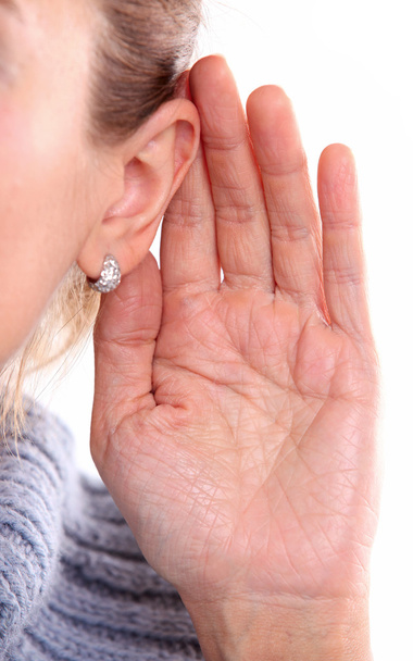 Ouvindo: visão de perto da mão feminina em sua orelha
 - Foto, Imagem