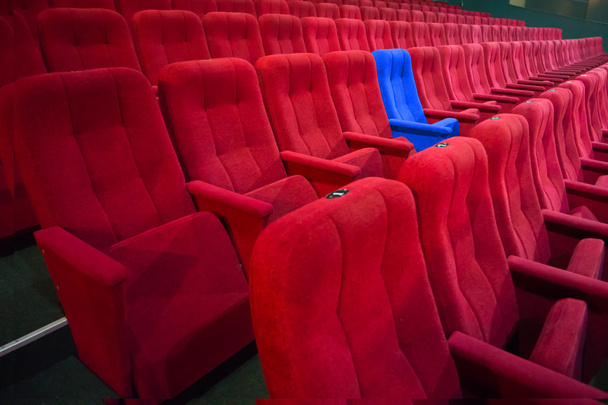 Sedia blu tra file di sedili rossi
 - Foto, immagini