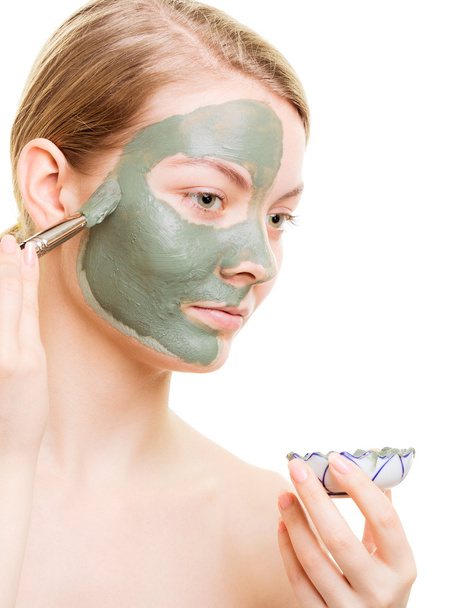 Girl applying facial clay mask to her face - Fotoğraf, Görsel