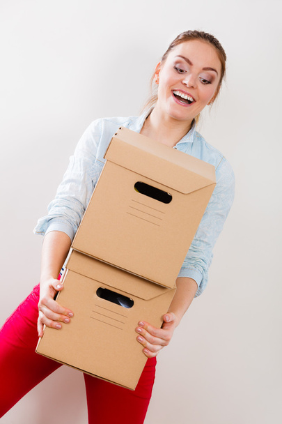 Happy woman moving into house carrying boxes. - Foto, imagen