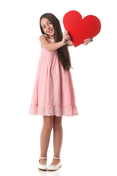 Bella ragazza che tiene una forma di cuore rosso, su sfondo bianco
 - Foto, immagini