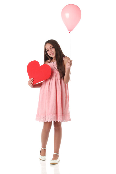 Belle fille tenant une forme de coeur rouge et un ballon rose
 - Photo, image