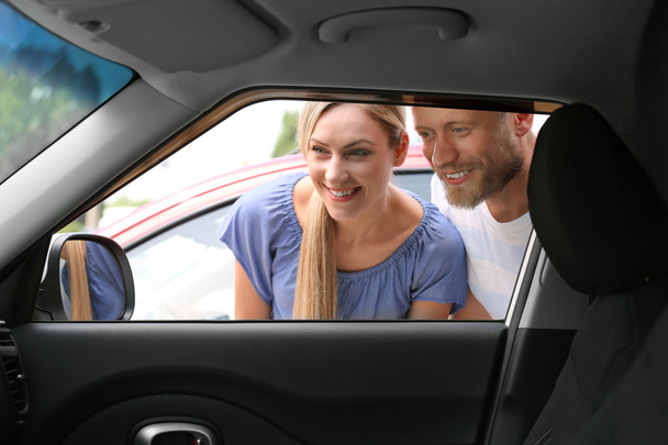 Young couple looking inside car - Фото, зображення