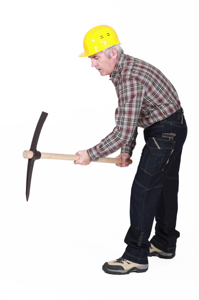A mature construction worker using a pickaxe. - Photo, Image