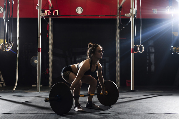 woman lifting heavy barbell - Photo, Image