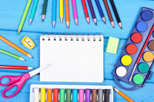 School accessories on blue boards, back to school concept, copy space for text in notepad - 写真・画像