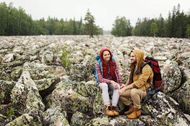  туристи, що сидять на камені
 - Фото, зображення