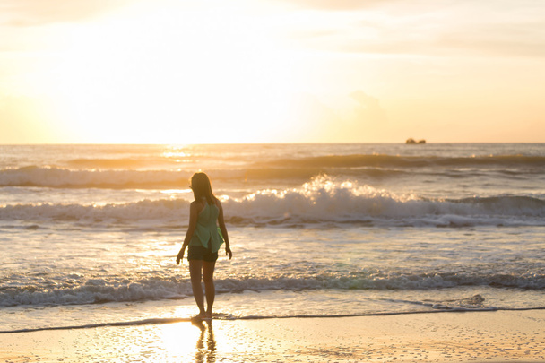 woman walking on the beach, sunshine in the morning summer sea - Valokuva, kuva