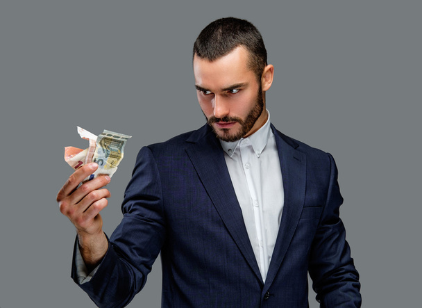 Bebaarde man in een pak geld houden - Foto, afbeelding
