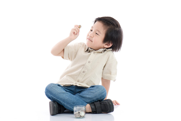 Mignon asiatique enfant économiser de l'argent en bouteille en verre
 - Photo, image