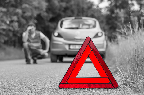 Kırık araba yolda ve kırmızı üçgen ile mutsuz sürücü - Fotoğraf, Görsel