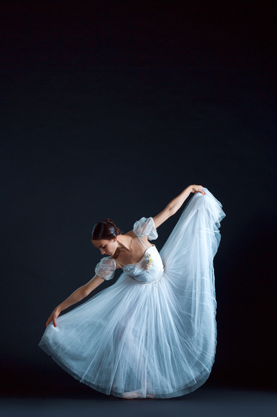 Portrait of the classical ballerina in white dress on black background - Fotoğraf, Görsel