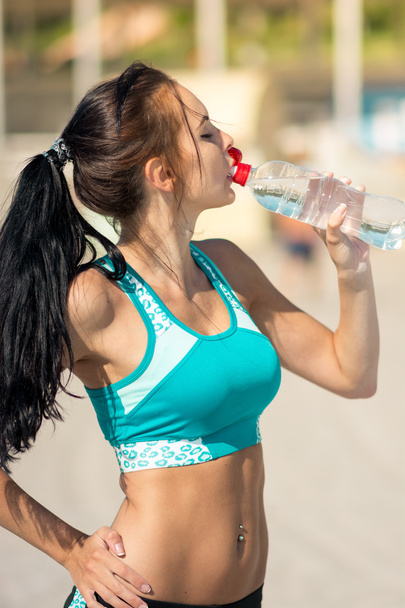 Fitness mujer beber agua después de correr en la playa
 - Foto, Imagen