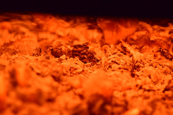 Ζεστά κάρβουνα στη σόμπα. Κόκκινο καίγεται από τη θέρμανση του δέντρου σωματίδια. - Φωτογραφία, εικόνα