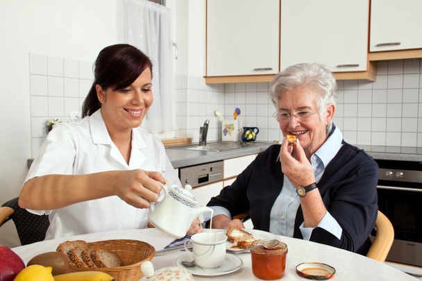 Krankenschwester hilft Seniorin beim Frühstück - Foto, Bild