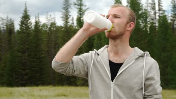Young muscular build man drinking water of bottle after running, - Footage, Video